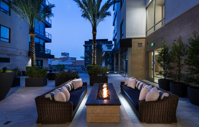 Alternate view of the outdoor firepit and seating area showing the stone material of the modern rectangular firepit.