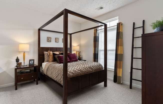 a bedroom with a four poster bed and a ladder