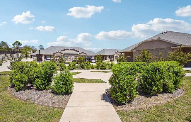 A residential area with houses and green bushes.