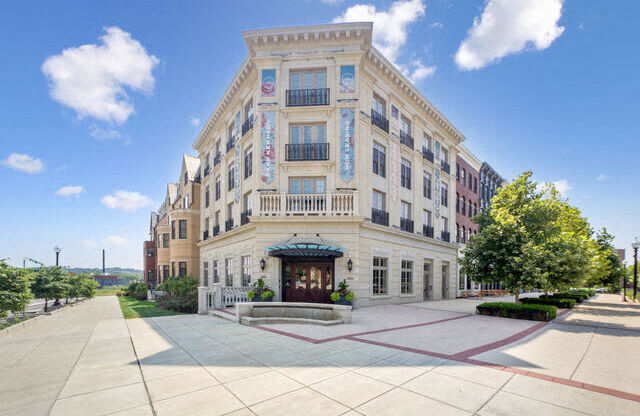 a large white building with a sidewalk in front of it