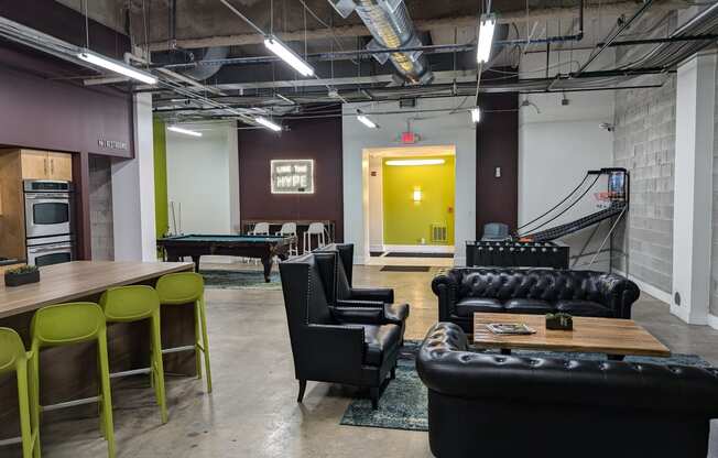 a living room with couches and chairs and a pool table