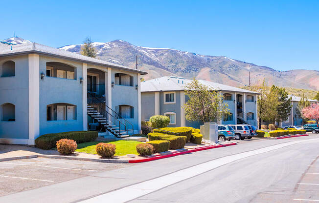 a row of apartment buildings with mountains in the background