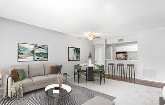 a living room with a couch a table and a chair and a kitchen in the background at Lakes Edge Apartments, Greensboro, North Carolina