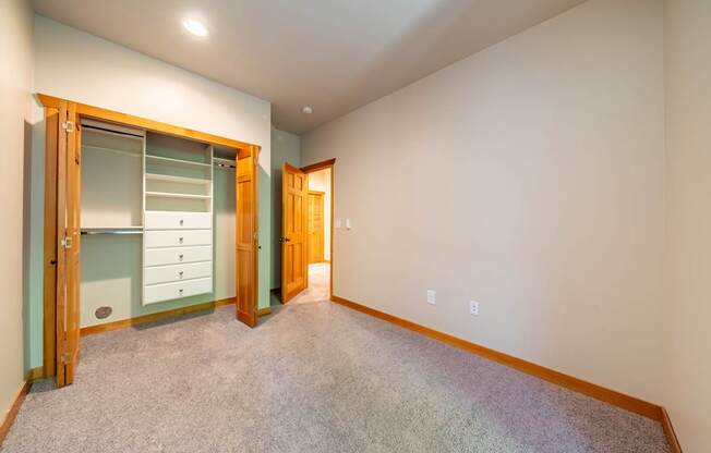A room with a carpeted floor and a wooden door.