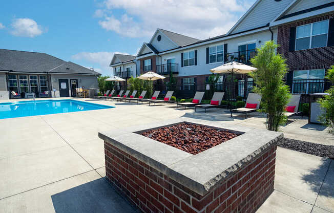 A pool area with a fire pit in the middle of it.
