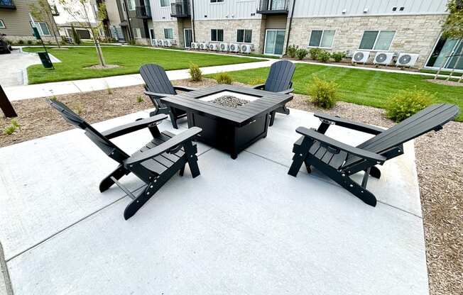 a patio with a fire pit and chairs