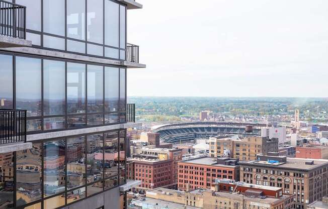 A view from a high-rise building looking out over a cityscape with a stadium in the distance.