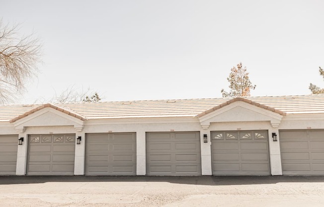 A house with a grey roof and four garages.
