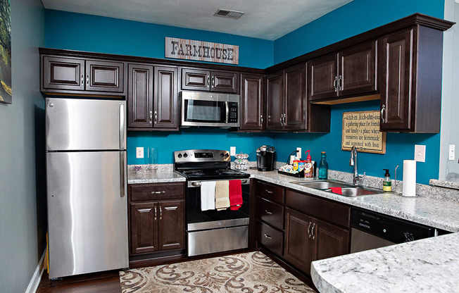 a kitchen with dark cabinets and a blue wall