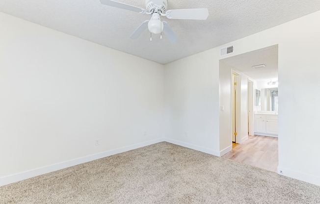 a bedroom with white walls and a ceiling fan at Redlands Park Apts, Redlands, CA