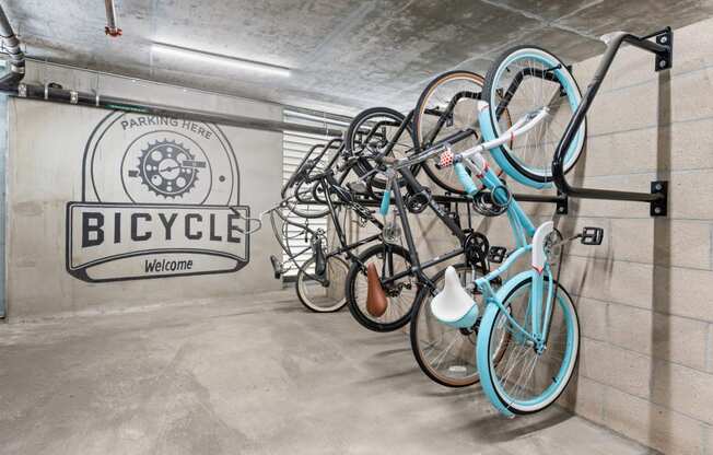 a group of bikes hanging on a wall in a bike garage