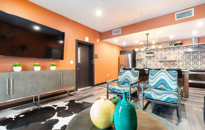 a living room with orange walls and a black and white rug