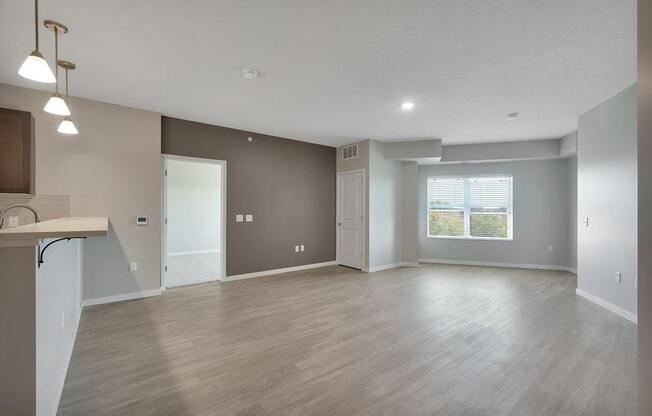 A spacious living room with a kitchenette and a view of the outdoors.