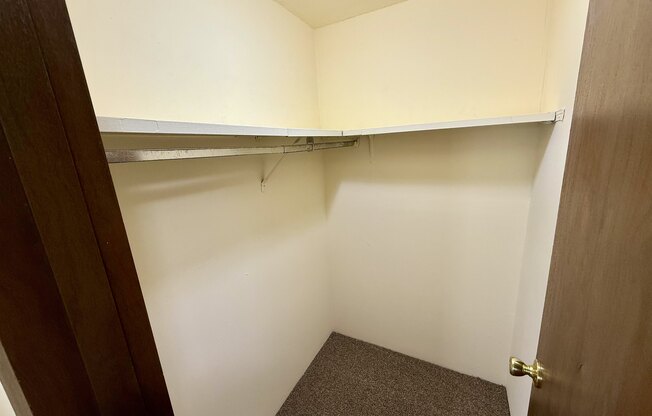 A small, empty room with a carpeted floor and a door on the right.