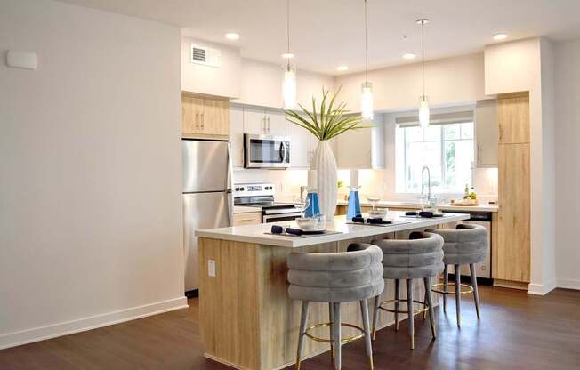 A kitchen with a white island and bar stools.