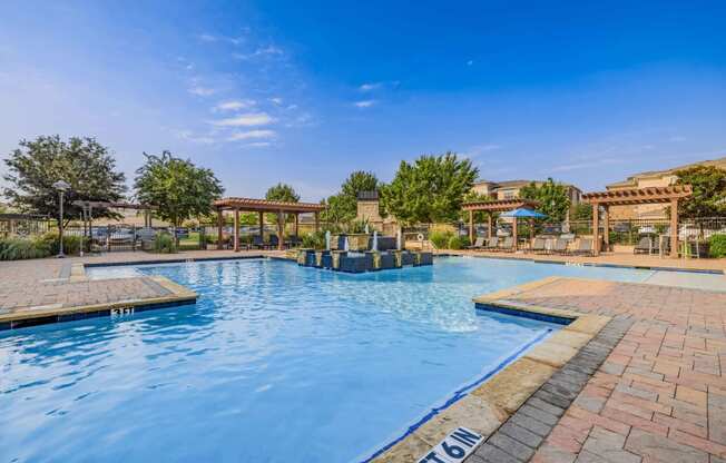 a swimming pool with trees and a blue sky above it