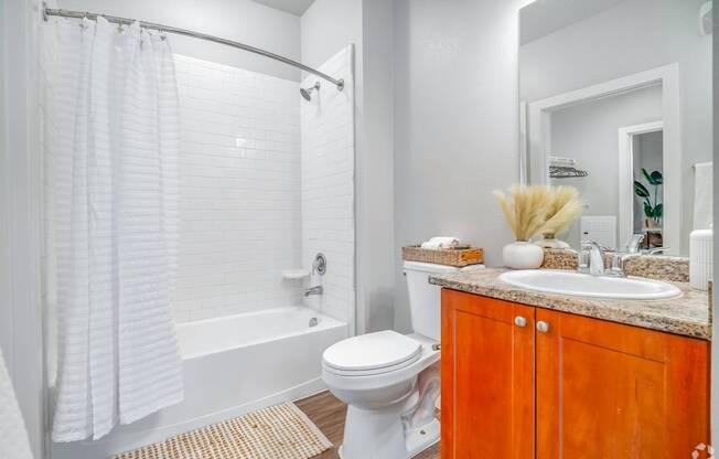 A white bathroom with a toilet, sink, and shower.
