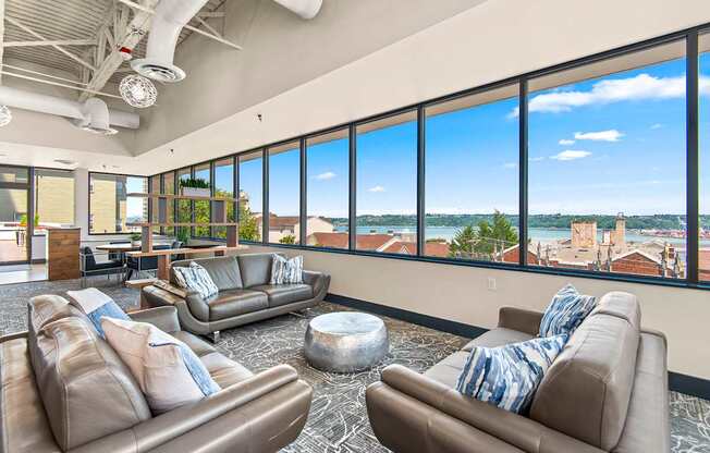 A living room with two couches and a large window overlooking a cityscape.