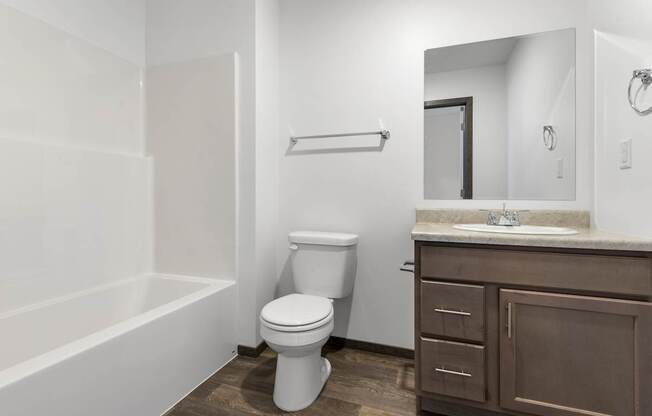 A white toilet sits in a bathroom with a brown cabinet.