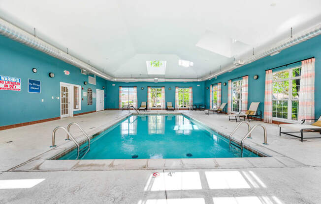 a swimming pool with blue walls and a skylight