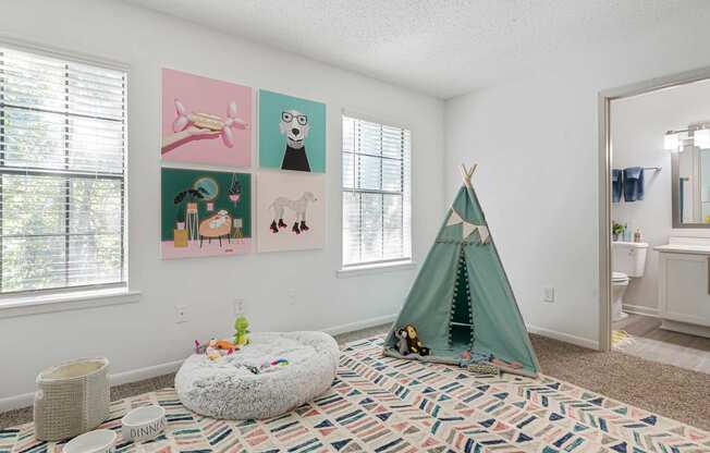 a bedroom with a teepee and pictures on the wall