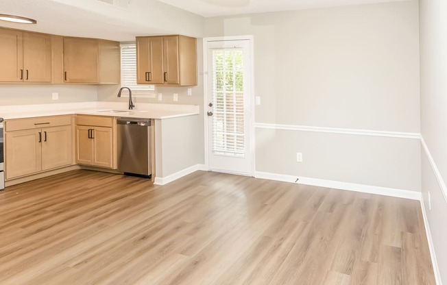 empty dining area and kitchen with wood cabinets