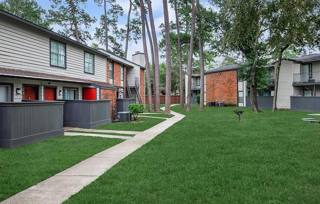 a house with a lawn in front of a brick building