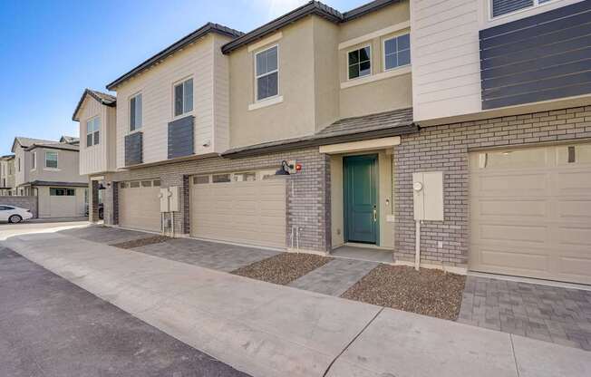 A row of houses with garages and driveways.