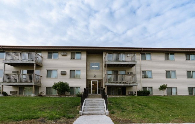 an apartment building with stairs and a green lawn. Moorhead, MN South Park Apartments