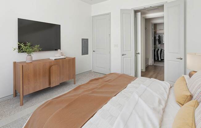A bedroom with a large bed and a tv on a cabinet.
