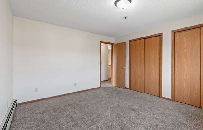 an empty living room with carpet and wood doors