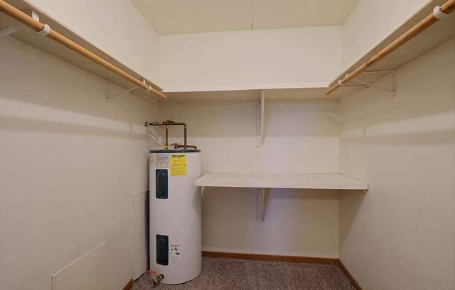 a closet with shelves and a water heater. Fargo, ND Dakota Manor Apartments