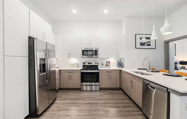 A modern kitchen with stainless steel appliances and wooden floors.