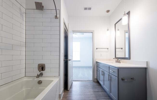 a bathroom with a tub and a sink and a mirror