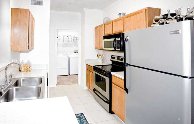 A modern kitchen with a stainless steel refrigerator, microwave, and oven.