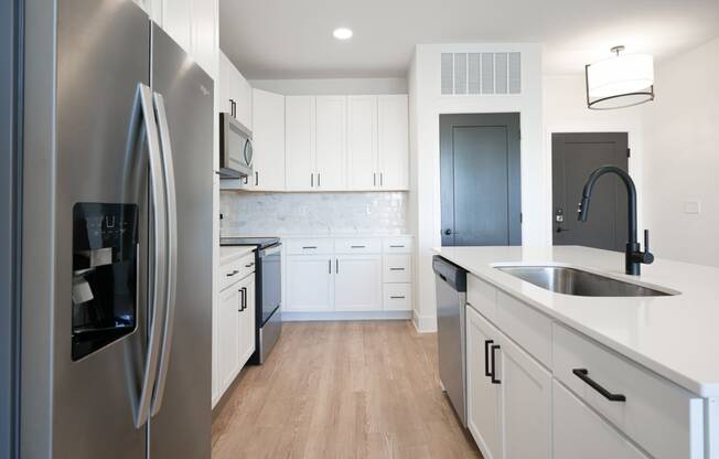 a kitchen with white cabinets and stainless steel appliances