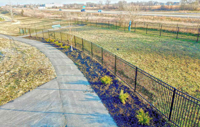 a path running through a park next to a fence