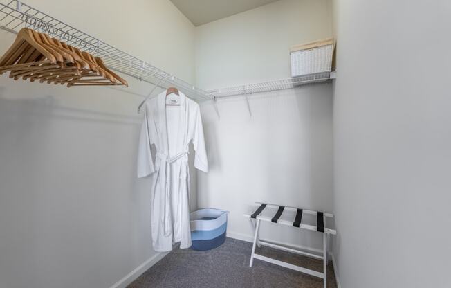 a dressing room with a white robe and wooden hangers