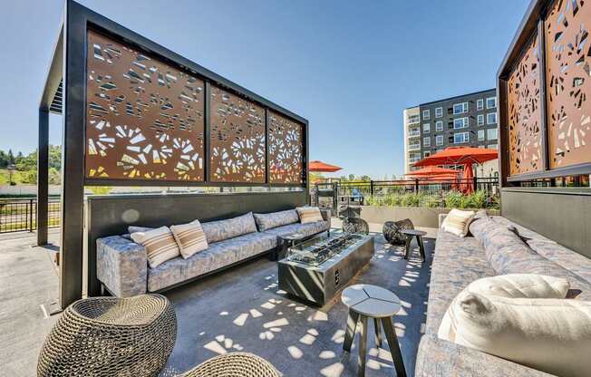 A modern outdoor seating area with a large sofa and wicker tables.