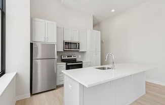 A modern kitchen with white cabinets and stainless steel appliances.