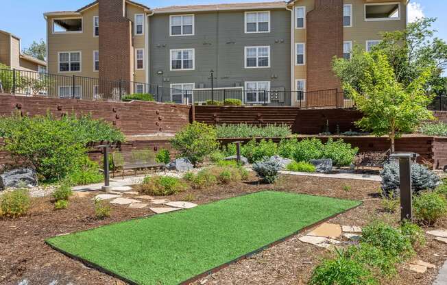 a garden with a lawn in front of an apartment building at Arcadia Apartments, Centennial, CO 80112