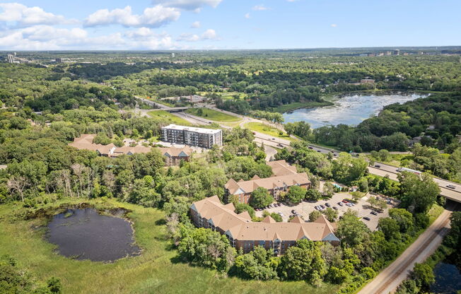 an aerial view of a campus with a lake and buildings