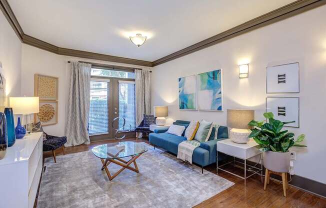 A living room with a blue couch and a white coffee table.