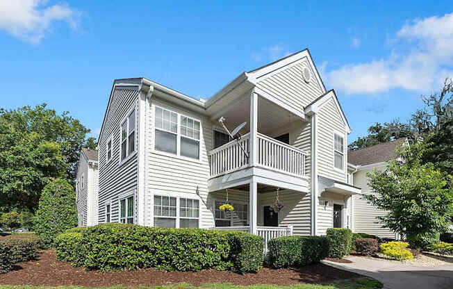 A two-story house with a balcony on the second floor.