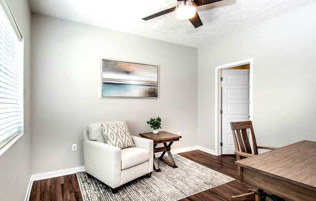 A living room with a white couch, a wooden coffee table, and a painting on the wall.