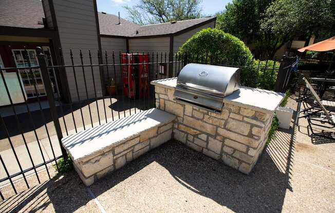 View of grilling station in fenced pool area with counters to prep food