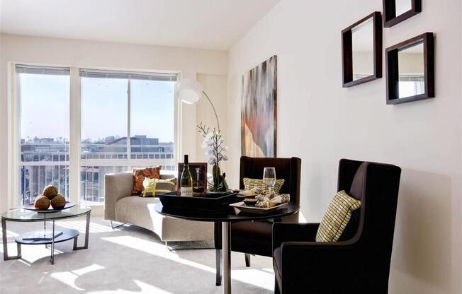 A black chair sits in front of a table with a wine glass on it.