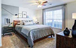 A bedroom with a large bed and a ceiling fan.