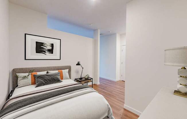 A bedroom with a large bed and a painting on the wall.