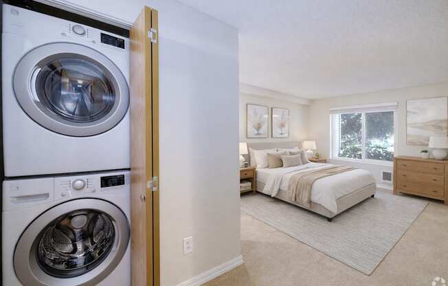 A washer and dryer are built into a wall in a bedroom.